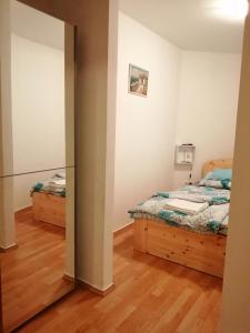 1 dormitorio con 2 camas y espejo en Reza apartman, en Cserkeszőlő