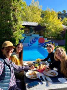 Camping Alta Ribagorça في إل بونت دي سويرت: مجموعة من الناس يجلسون على طاولة يأكلون الطعام