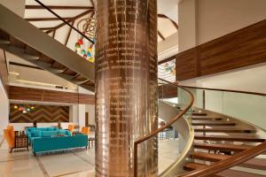 een wenteltrap in een gebouw met een lobby bij Hawthorn Suites by Wyndham Dwarka in Dwarka