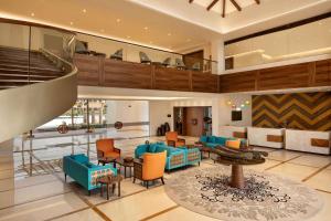 a lobby with blue and orange chairs and tables at Hawthorn Suites by Wyndham Dwarka in Dwarka