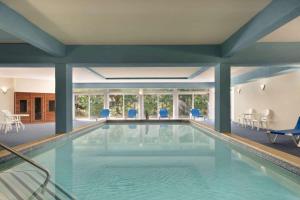 a swimming pool in a house with blue chairs at Days Inn by Wyndham Tamworth in Tamworth