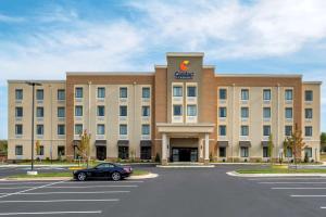 a building with a car parked in a parking lot at Comfort Inn & Suites in Winchester