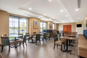 a dining room with tables and chairs and windows at Comfort Inn & Suites in Winchester