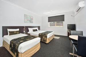 a hotel room with two beds and a television at Comfort Hotel Dandenong in Dandenong
