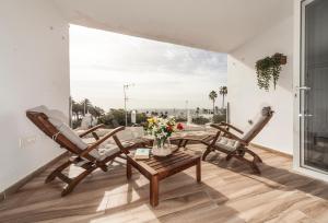 a balcony with two chairs and a table with flowers at Apartamentos los volcanes in Puerto del Carmen