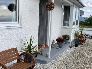 a house with a porch with benches and plants at Skerrols in Broadford