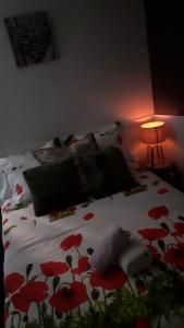 a bedroom with a bed with red flowers on it at Appartement 48m2 pour 6 personnes au centre ville historique avec parking gratuit et une borne de recharge pour voiture à 10 metres in Avallon
