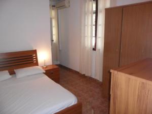una camera da letto con un letto bianco e un armadio in legno di Sunway Residence a Mont Choisy
