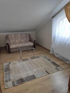 uma sala de estar com um sofá e um tapete em Сімейний відпочинок em Truskavets