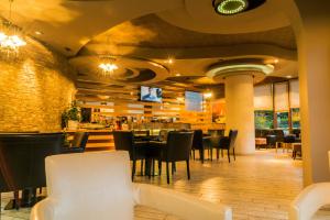 a restaurant with tables and chairs and a bar at Hotel George in Korçë