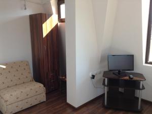 a living room with a chair and a computer on a table at Guest House Luchi in Varshets