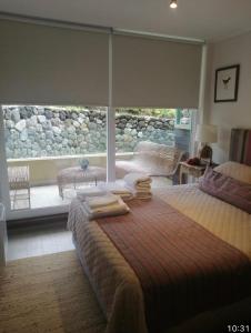 una camera da letto con due letti e una grande finestra di Departamento Pucon espectacular a Pucón Altre 7 foto