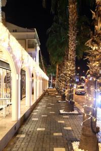 a sidewalk with palm trees and christmas lights at Sealife Lounge - Adult only in Antalya