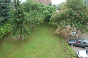 une voiture garée dans une cour avec des arbres et des chaises dans l'établissement Marronnier, à Epfig