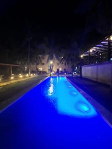 uma piscina iluminada à noite com luzes azuis em Pecem Beach Hotel - Aval Hotel em Pecém