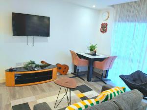 ein Wohnzimmer mit einem Tisch und einem TV in der Unterkunft Great Studio Serviced Apartments - Netflix, Wifi, Digital TV in Sheffield