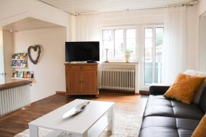 een woonkamer met een bank en een tv bij Ferienwohnung am Stemberg in Detmold