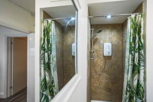 a bathroom with a shower with a glass door at Private, Detached Annex with On-Street Parking in Cardiff