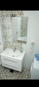 een badkamer met een witte wastafel en een spiegel bij Horizont city in Banja Luka