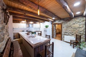 een keuken met een groot eiland en een stenen muur bij Casa Pion in Sober