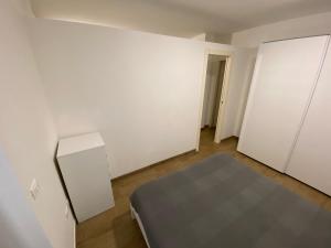 une chambre vide avec un lit et des murs blancs dans l'établissement Villa Canepa, à Diano Marina