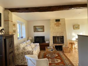 a living room with a couch and a fireplace at La Longere du Haras in Manerbe