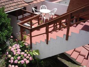 a balcony with a table and chairs and flowers at Hotel Aldea Marina in Villa Gesell