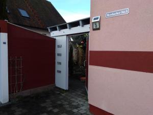 ein rot-weißes Gebäude mit einer Garage in der Unterkunft Scharfs Kämmerla in Baiersdorf