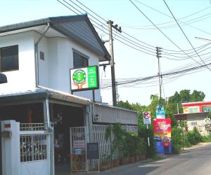 un restaurante con un cartel en el lateral de un edificio en Ban Maitree, en Chiang Mai