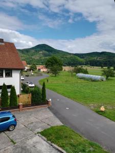 Kleinvach的住宿－Ferienhaus Bine，路边有一辆蓝色汽车的房子