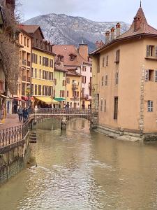 a bridge over a river in a city with buildings at Le lavoir in Rumilly