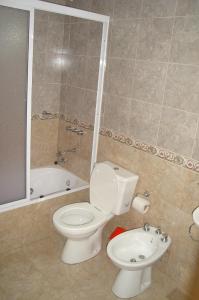 een badkamer met een toilet, een wastafel en een bad bij Cabañas Aldea Serrana in Sierra de la Ventana