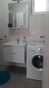 bagno con lavatrice e lavandino di Family Holiday Home a Turanj (Torrette)