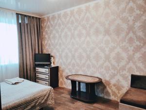 Shostka的住宿－центр вулиця Миру，一间卧室配有一张床、一张桌子和一台电视。