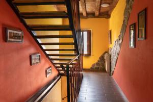 un pasillo con una escalera en una casa con paredes de color naranja en B&B Al Vecchio Confine, en Cervignano del Friuli