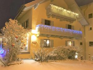 une maison dotée d'un balcon avec des lumières de Noël. dans l'établissement Maier Pension, à Bayerisch Eisenstein