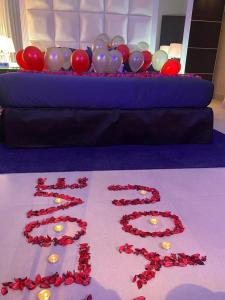 a table with red roses and balloons on the floor at Dana Hotel & Residences in Riyadh