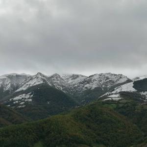 a snowy mountain range with trees and snow covered mountains at APARTAMENTOS RURALES EL PRIVILEGIO in La Plaza