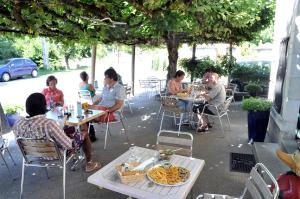a group of people sitting at tables in a patio at Auberge Magnette in Audes