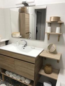 La salle de bains est pourvue d'un lavabo et d'un miroir. dans l'établissement Appartement climatisé F3 proche plage port et aéroport, à Ajaccio