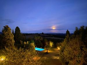 uitzicht op een zwembad in een tuin 's nachts bij Agriturismo Spazzavento in Palazzone