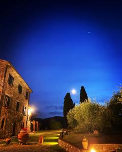 a night view of an old building with the moon in the sky at Agriturismo Spazzavento in Palazzone