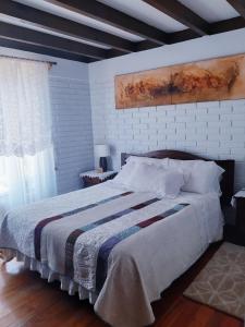 a bedroom with a large bed with a blanket at Casa Emiluz in La Serena