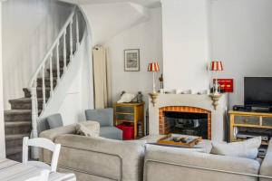 ein Wohnzimmer mit 2 Sofas und einem Kamin in der Unterkunft La maison bleue in Cabourg
