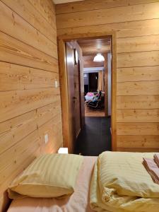 1 dormitorio con paredes de madera y 1 cama en una habitación en Les Crosets Apartment Miroi 23, Val d'Illiez, en Les Crosets