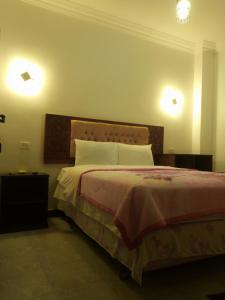  نزل اربيان نايتس في القاهرة: غرفة نوم مع سرير مع مصباحين على الحائط
