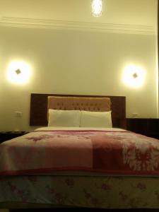 een slaapkamer met een bed met twee lampjes aan de muur bij Arabian Nights Hostel in Caïro