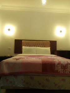 a bedroom with a bed with two lights on the wall at Arabian Nights Hostel in Cairo
