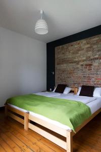 - une chambre avec un grand lit et un mur en briques dans l'établissement Schickes Bielefeld Zentrum Appartement, à Bielefeld