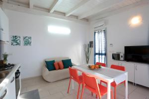 uma cozinha e sala de estar com mesa e cadeiras em Casa Canoa - Le chiavi degli Iblei em Punta Braccetto